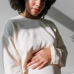 ethic women holding pregnant belly and smiling camera